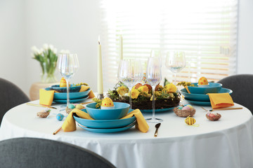 Festive Easter table setting with beautiful floral decor and eggs indoors