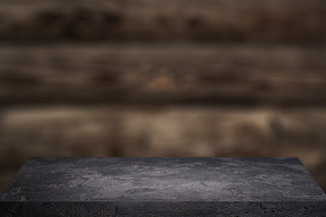 Black stone surface on wooden background .