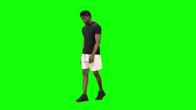 African american man is walking at Green Screen, Chroma Key. Front view.
