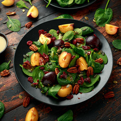 Vegan plums salad with cranberry, pumpkin seed, pecans nuts, spinach and mustard dressing
