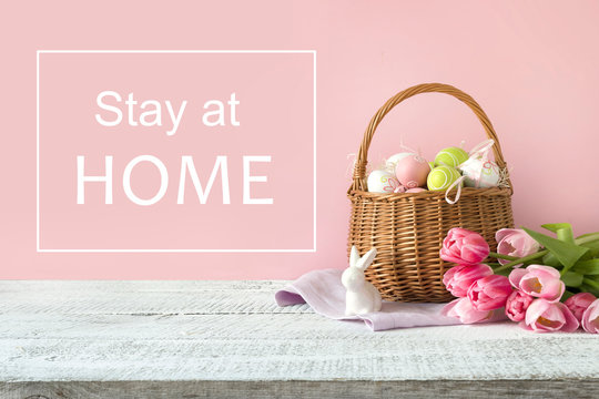 Wicker basket with easter eggs and pink tulips. Spring easter pink background with space for text.