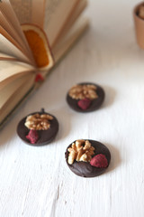 Dark chocolate with nuts, dry fruits -homemade candies. Delicious snak on a white background