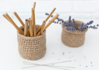 reusable bamboo cans for drinks in a jute basket with lavender in the background, preserve nature without plastic. horizontal frame with place for test
