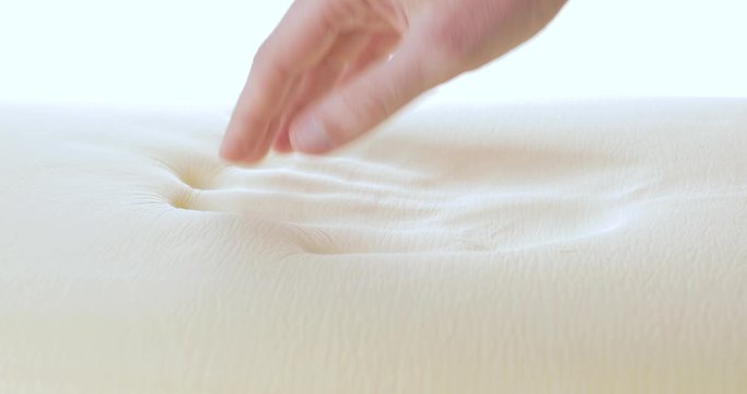 Mano sta toccando un materasso in poliuretano con tecnologia memory foam.