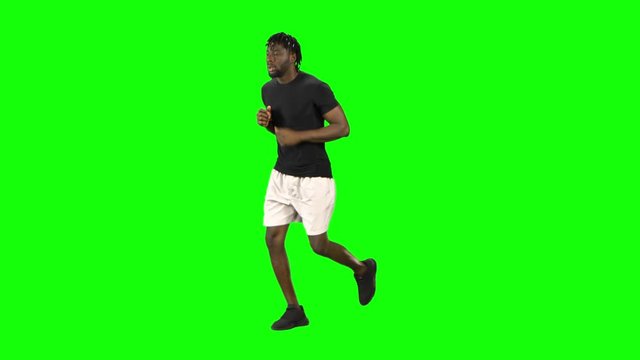 African american man is running at Green Screen, Chroma Key.