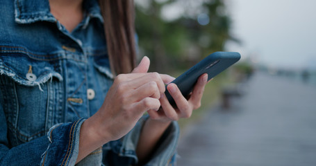 Woman wear blue jeans and use of smart phone at outdoor