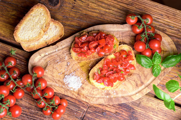 Italian bruschetta, toasted bred with fresh tomato and basil on woody vintage table