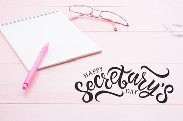 Woman desk with notebook, pink pen and glasses