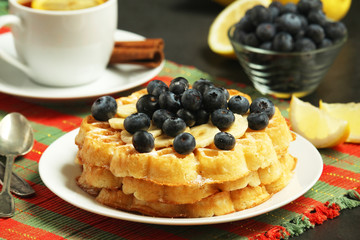 Belgian waffles with blueberry and a cup of tea with lemon