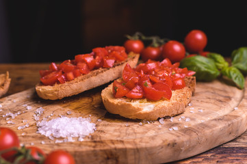 Italian bruschetta, toasted bred with fresh tomato and basil on woody vintage table