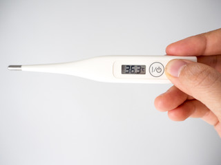 Hand hold digital thermometer  display body temperature.