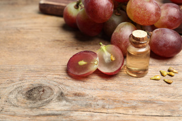 Fototapeta na wymiar Natural grape seed oil on wooden table. Organic cosmetic