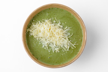 Tasty healthy hot cream spinach soup, or broccoli with crackers and parmesan in a cardboard bowl for take away or food delivery isolated on a white background.