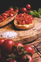 Italian bruschetta, toasted bred with fresh tomato and basil on woody vintage table