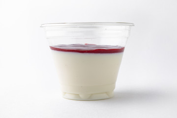 Dessert delicious pudding, panacota or jelly made from vanilla, jam and chocolate package in a plastic cup for take away or food delivery isolated on a white background.