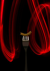 Macaroni strung on a fork on a black background with a red light line