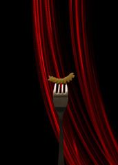 Macaroni strung on a fork on a black background with a red light line