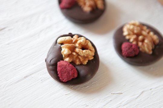 Dark chocolate with nuts, dry fruits -homemade candies. Delicious snak on a white background