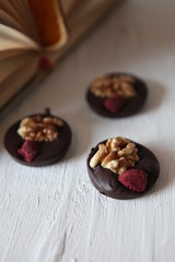 Dark chocolate with nuts, dry fruits -homemade candies. Delicious snak on a white background