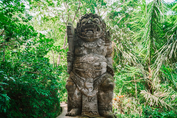 Statue of the Balinese spirit guarding a Hindu temple against the background of the jungle. Statue...