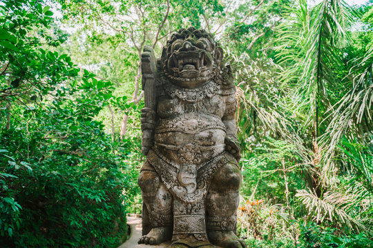 Statue of the Balinese spirit guarding a Hindu temple against the background of the jungle. Statue in Bali in the jungle. Traditions and culture of Bali.