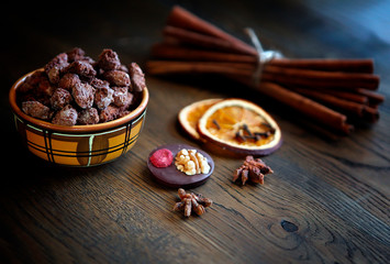 Mix nuts, dry fruits and chocolate at ceramic bowl on the wooden table. rustic style. tasty and delicious sweeties.