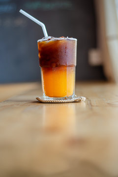 Ice coffee, americano coffee with orange in cafe.