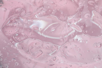 Pure transparent cosmetic gel on pink background, closeup