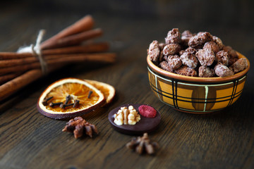 Mix nuts, dry fruits and chocolate at ceramic bowl on the wooden table. rustic style. tasty and delicious sweeties.