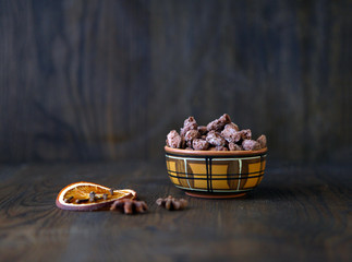 Mix nuts, dry fruits and chocolate at the ceramic bowl on wooden background