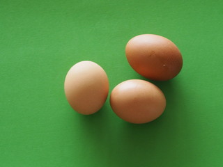 Fresh three eggs on green background