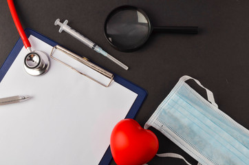 Flat lay view of medical and healthcare background concept. Stethoscope, red heart, magnifying...