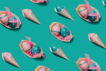 Naklejka premium Pattern with colored decorated eggs in bamboo cones look like ice cream and boat plates on green mint background. Concept of Easter, zero waste, ecology, copy space.