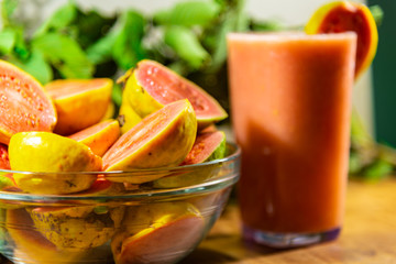 Guava juice (Psidium guajava) and fresh fruits broken in a glass bowl
