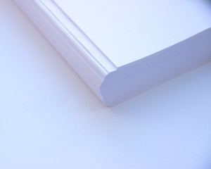 Corner of a ream of 500 sheets of paper on a white background