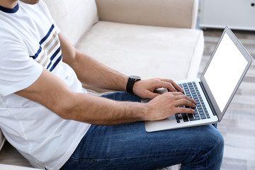 Fototapeta premium Man working on modern laptop at home, closeup