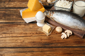 Fresh products rich in vitamin D on wooden table. Space for text