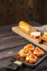 Smorrebrod or sandwich with Ricotta and salmon  on the cutting board.