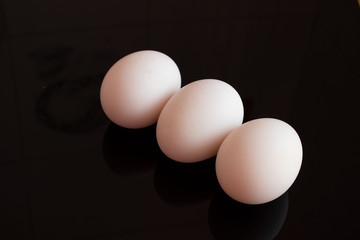 three eggs on black background