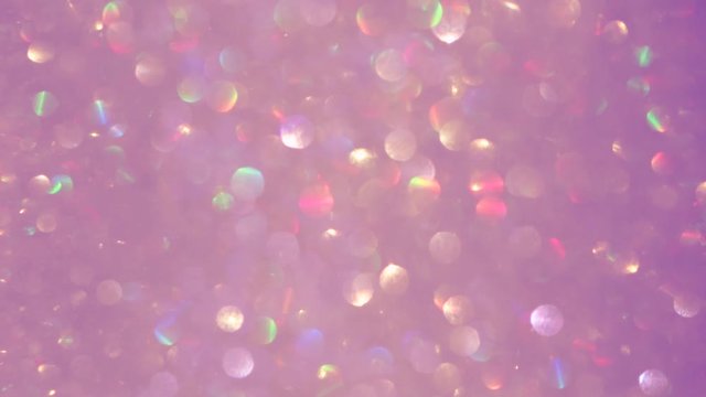 Closeup view video footage of beautiful sparkling pastel pink color blurry holiday background spinning around slowly.