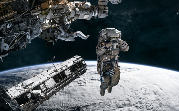 Astronauts, space stations in orbit of the Earth. Solar system. Science fiction. Elements of this image furnished by NASA