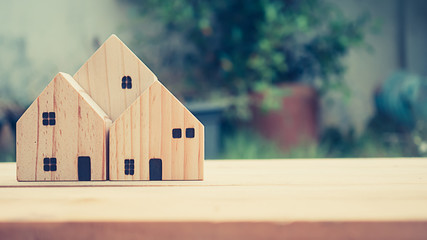 Obraz na płótnie Canvas House wooden model on wood background with copy space for text. Banking, real estate, investment, financial, savings concepts,vintage tone