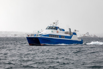 Fototapeta na wymiar Fast speed passenger boat arrives in Brønnøysund in northern Norway