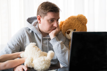 Young man in sports hoody at telework due to home quarantine of coronovirus pandemic...