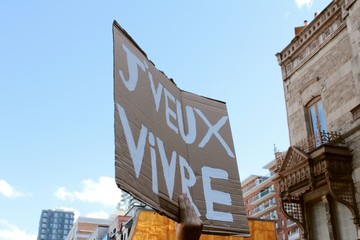 somebody holds a cardboard banner in French 