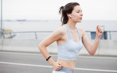 Fitness sport girl on intensive evening run, attractive runner jogging outdoors, female jogger in bright sportswear.