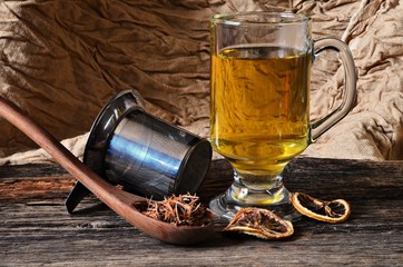 Glass of catuaba tea on a wooden board with a wooden spoon with catuaba bark