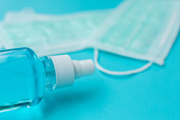 Surgical mask and spray alcohol for hand hygiene on blue background.for the prevention of the flu and the Coronavirus, covid-19. Health care concept.Top view