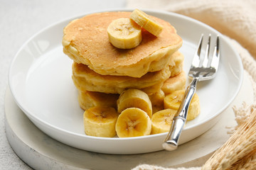 Delicious pancake with banana slices served on wooden table