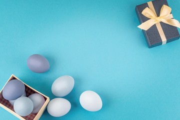 lots of blue and light blue Easter eggs next to an open gift box, spring composition, flatlay copyspace